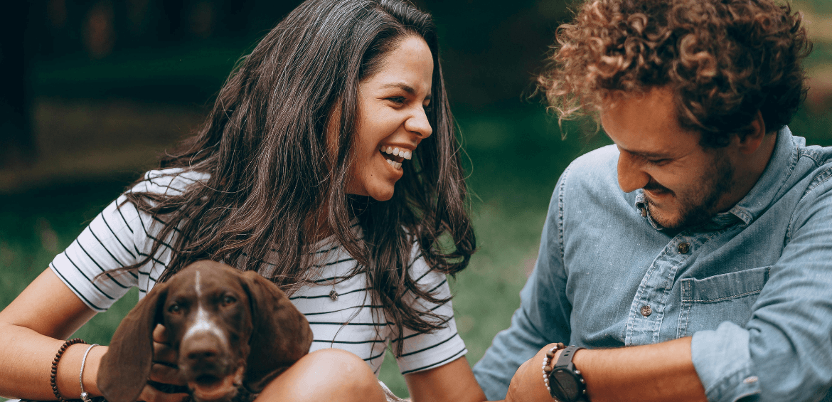 Photo of a couple laughing together with a dog