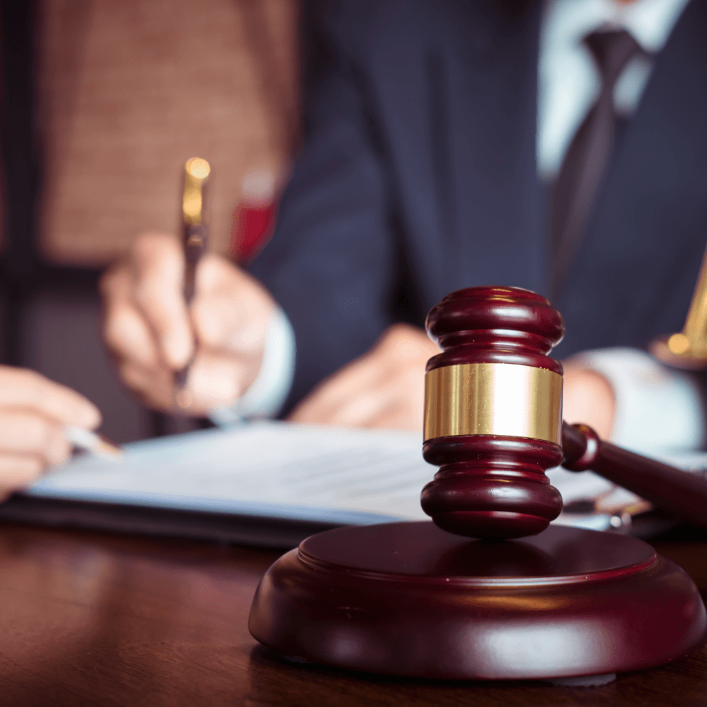 lawyer signing a document with gavel in foreground