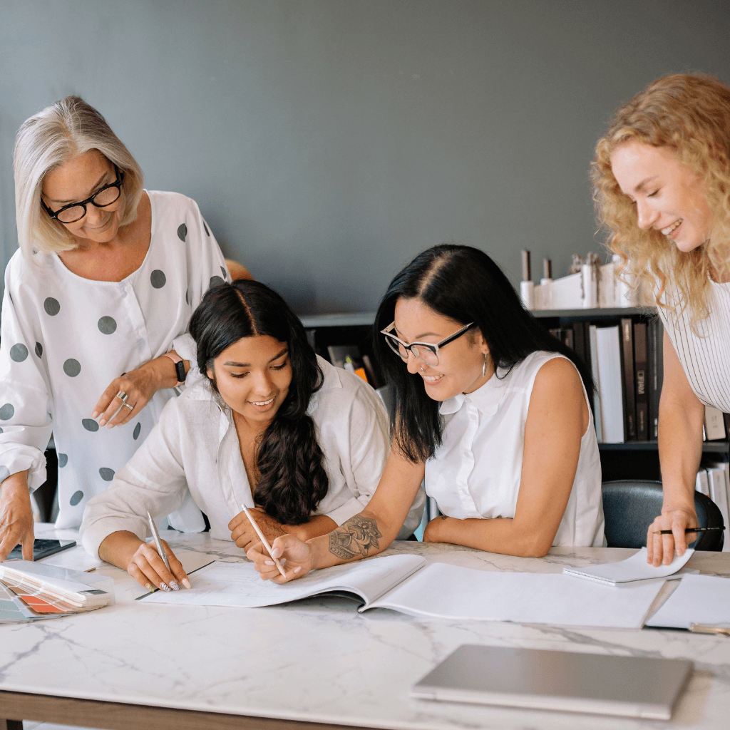 Women reviewing work together at a desk