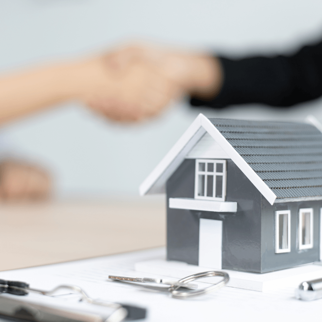 handshake with a house and keys in the foreground