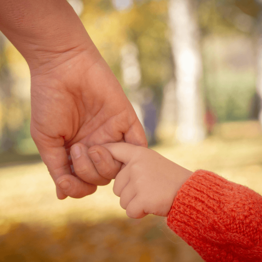adult holding a child's hand